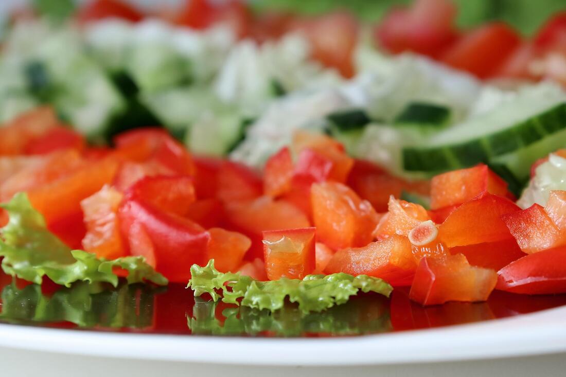 Diced tomatoes and cucumbers on a tray with lettuce