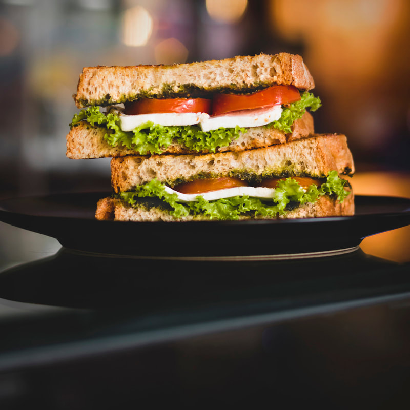 A tomato, mozzarella, and lettuce sandwich