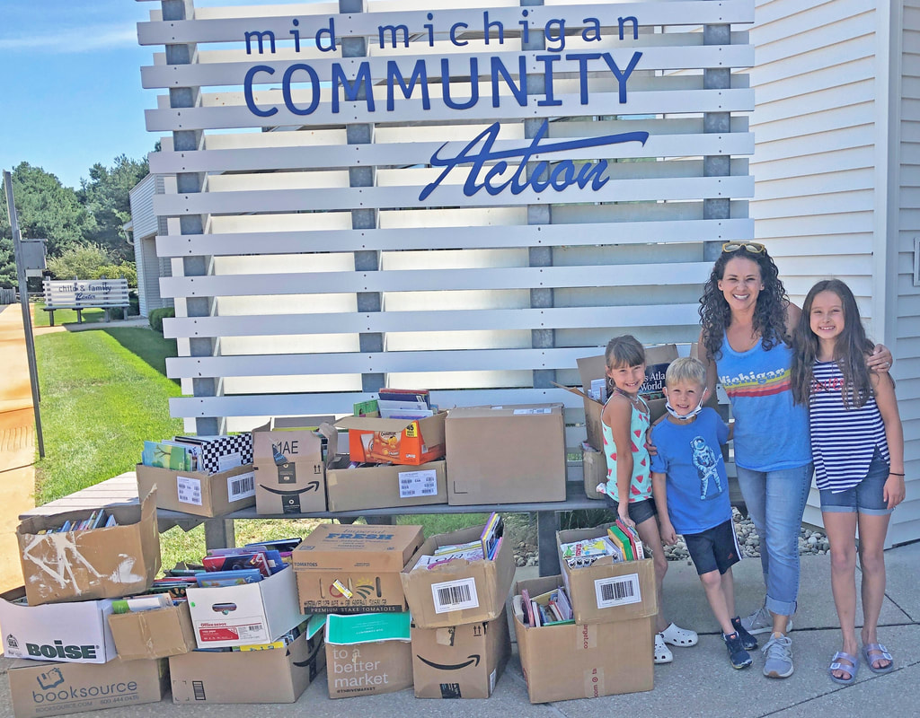 Maria and her children with the donated books as they dropped them off at MMCAA