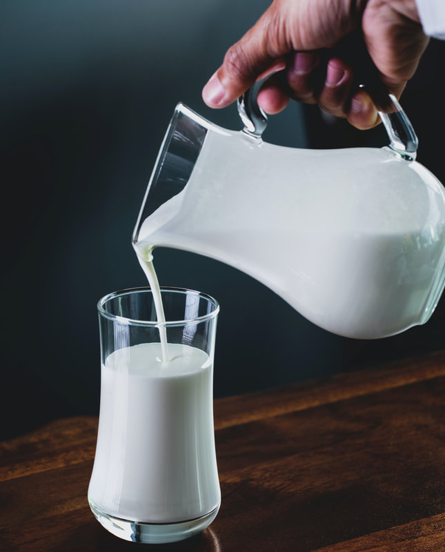 Pouring milk from a pitcher into a glass